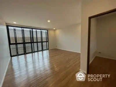 Spacious and well-lit corner unit with large windows and modern wooden flooring, ideal for a comfortable living room setup.