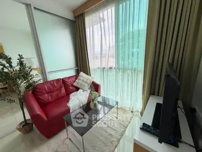 Cozy living room with red sofa and large window offering natural light and scenic view.