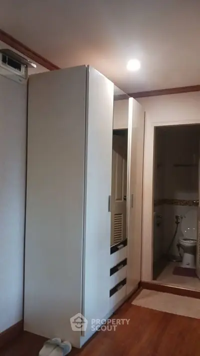 Compact bedroom with wardrobe and glimpse of bathroom