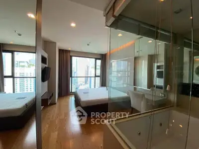 Luxurious modern bedroom with city view and glass-enclosed bathtub, perfect for urban living.