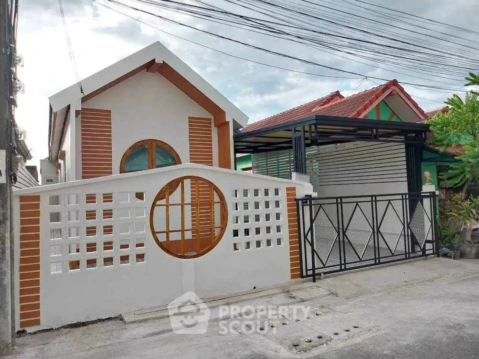 Charming modern house with unique circular window and gated entrance in a serene neighborhood.