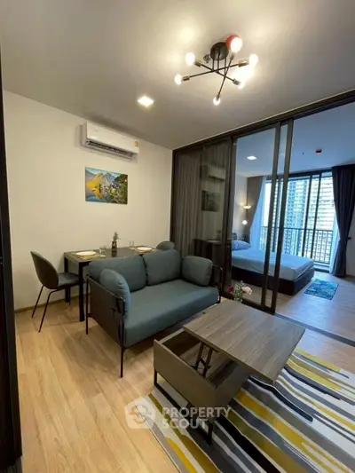 Modern living room with stylish furniture and a view into a cozy bedroom, perfect for urban living.