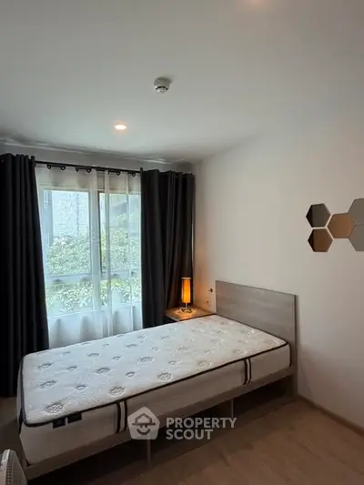 Cozy bedroom with natural light and modern decor in a stylish apartment.