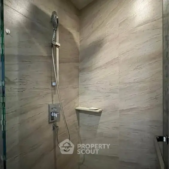 Modern bathroom shower area with sleek design and neutral tiles
