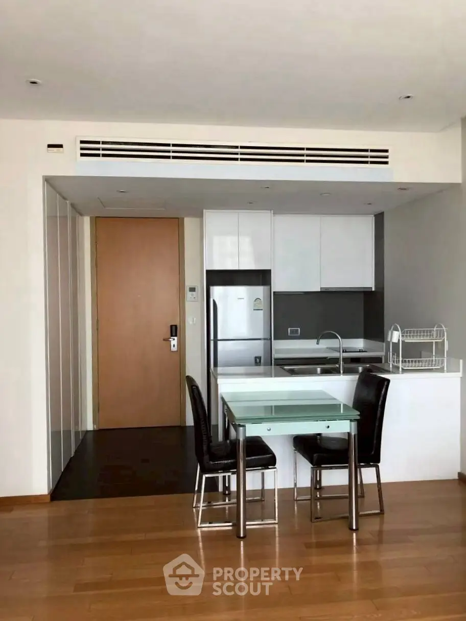 Modern open kitchen with sleek design and dining area in a stylish apartment.