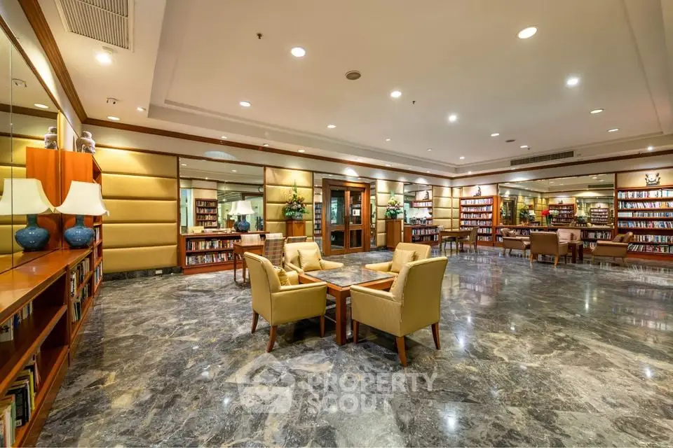 Luxurious library with elegant seating and marble flooring in upscale property.