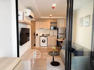 Modern living room with open kitchen and washing machine in stylish apartment.