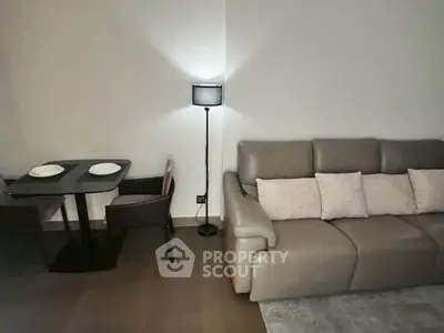 Modern living room with sleek leather sofa and stylish dining area