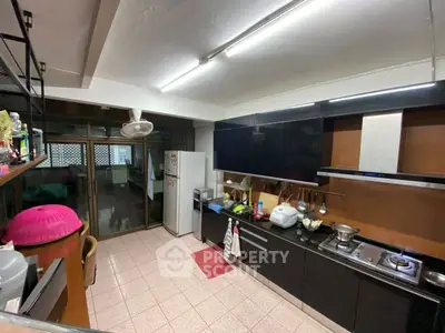 Modern kitchen with sleek black cabinets and stainless steel appliances