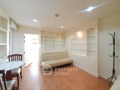 Bright and airy living space with sleek white shelving, modern sofa, and dining set, perfect for urban living.
