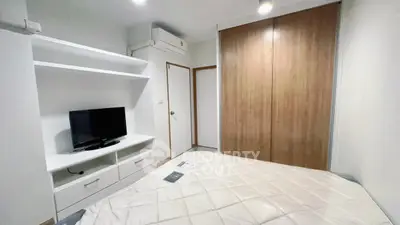 Modern bedroom with built-in wardrobe and TV unit in stylish apartment