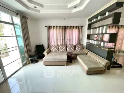 Spacious living room with modern sectional sofa and large windows for natural light.