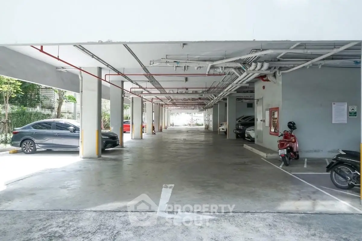 Spacious covered parking area with multiple vehicles in a modern residential building.