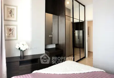 Modern bedroom with elegant decor and mirrored wardrobe in a stylish apartment.