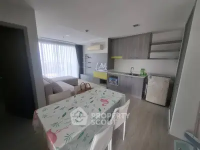 Modern open-plan living room and kitchen with stylish furniture and natural light.