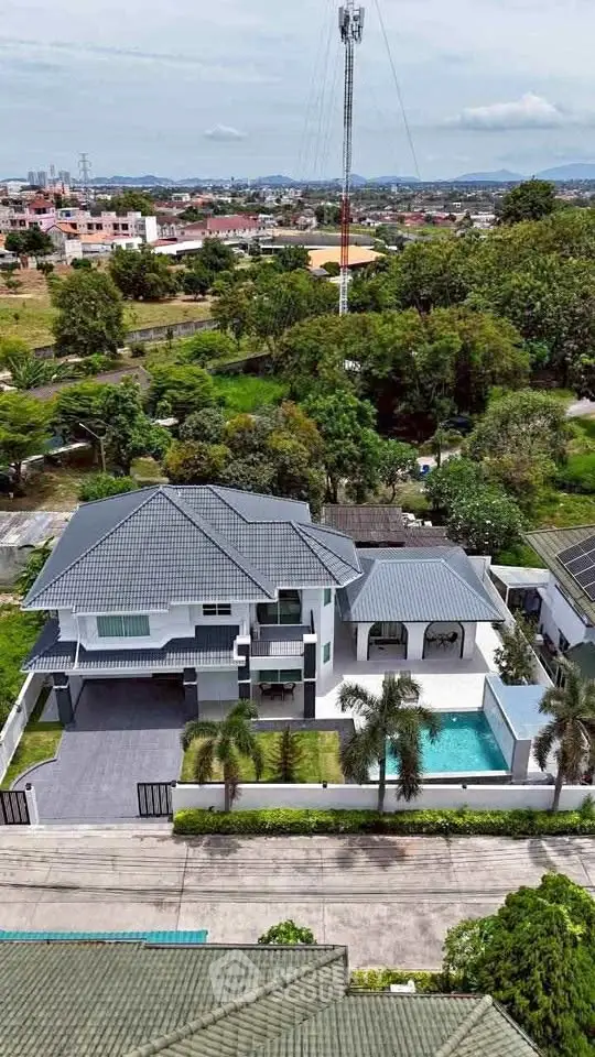 Luxurious modern villa with pool and lush garden in a serene neighborhood.