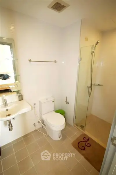 Modern bathroom with glass shower and sleek fixtures in a contemporary home.