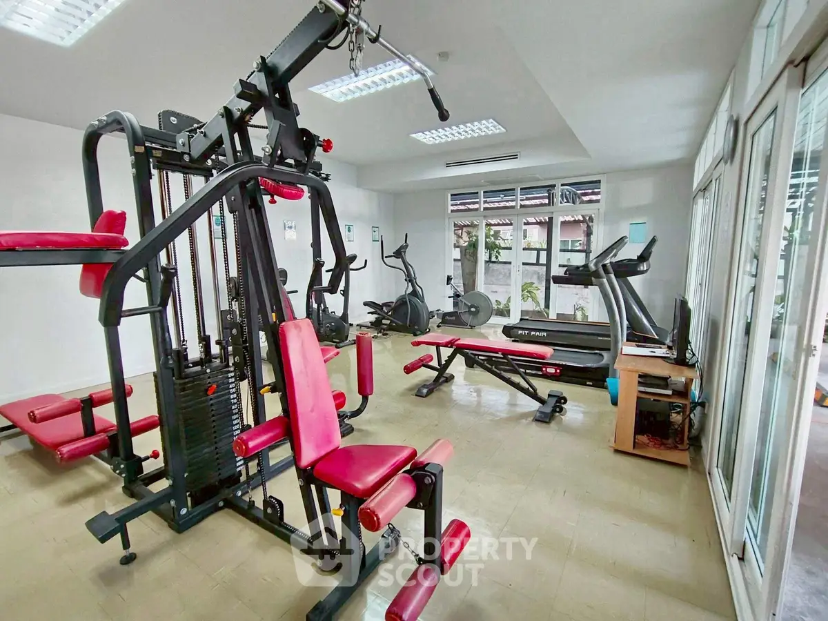 Modern gym with state-of-the-art fitness equipment and bright natural lighting.