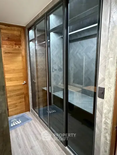 Modern bathroom with glass shower enclosure and wooden accents