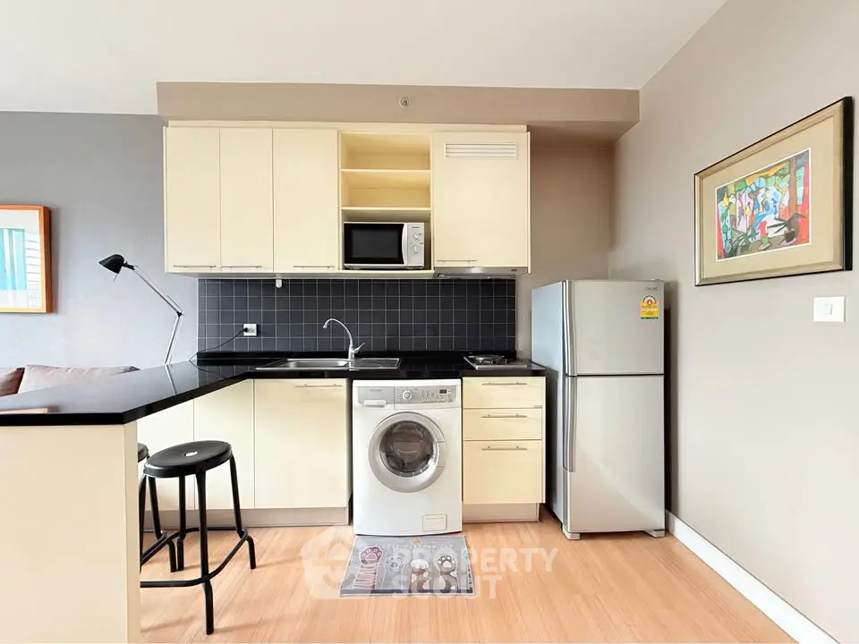 Modern kitchen with sleek appliances and stylish decor in a cozy apartment setting.