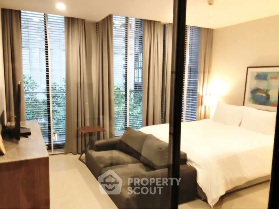 Luxurious bedroom with modern decor and large windows offering natural light.