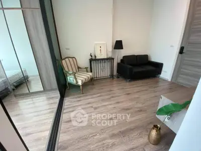 Modern living room with elegant decor and wooden flooring, featuring a cozy seating area and stylish accents.