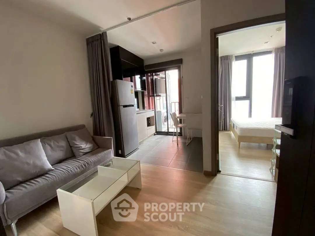 Modern open-plan living room with kitchen and bedroom in a cozy apartment.