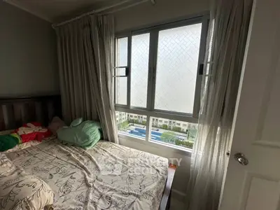 Cozy bedroom with a view of the pool, featuring a comfortable bed and large window.