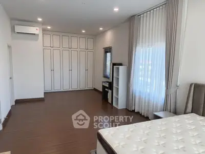 Spacious bedroom with elegant curtains and ample storage space