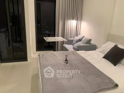 Modern bedroom with city view, cozy sofa, and elegant decor