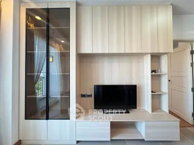 Modern living room with sleek wooden cabinetry and mounted TV, offering a stylish and functional space.
