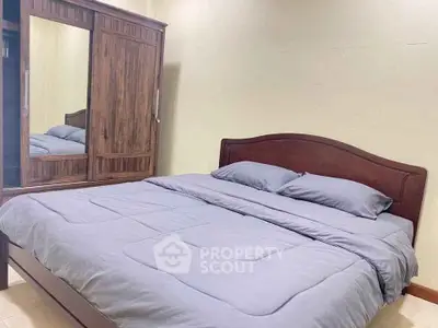 Cozy bedroom with wooden wardrobe and comfortable bedding