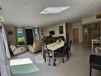 Spacious living room with modern furniture and ample natural light, perfect for family gatherings.