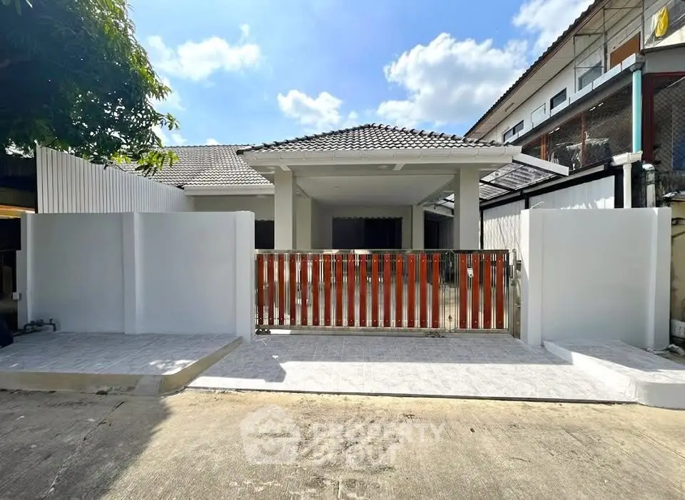 Charming single-story home with modern facade and gated entrance, perfect for family living.