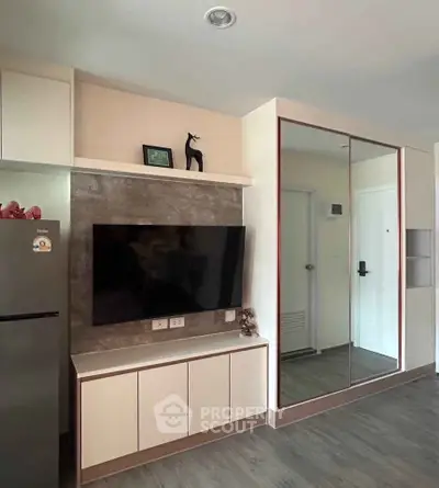 Modern living room with sleek TV setup and mirrored wardrobe, perfect for stylish urban living.