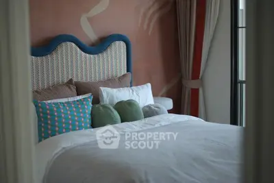 Cozy bedroom with stylish headboard and colorful pillows, perfect for relaxation.