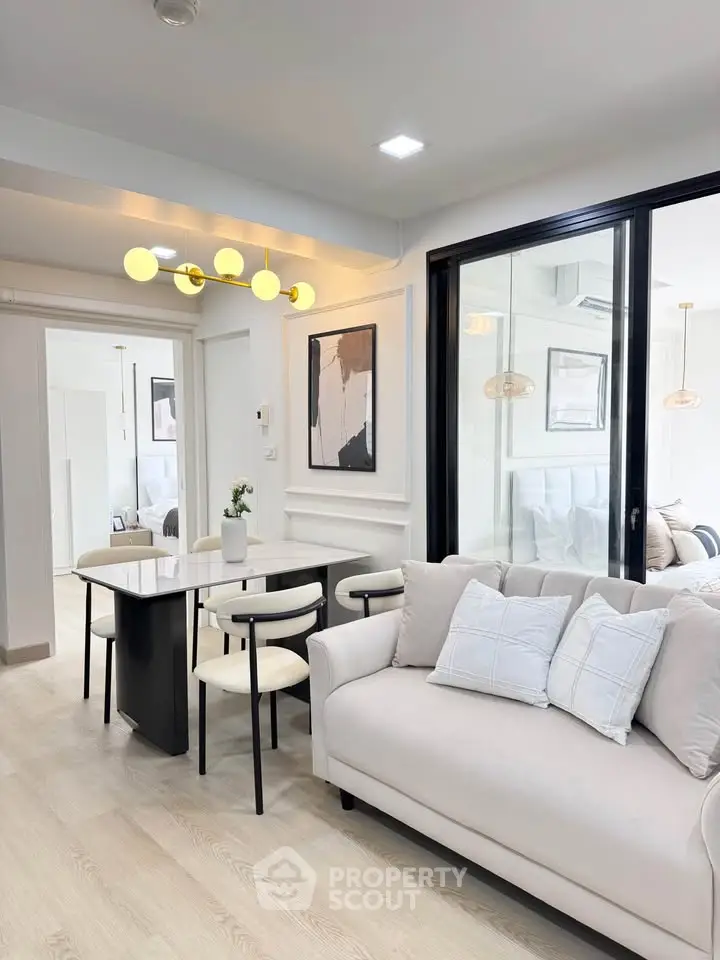 Modern living room with elegant decor and open layout, featuring a cozy sofa and stylish dining area.