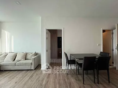 Modern living room with sleek dining area and cozy sofa, featuring elegant wood flooring.