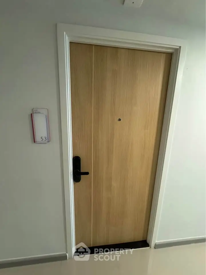 Modern apartment entrance with sleek wooden door and stylish handle