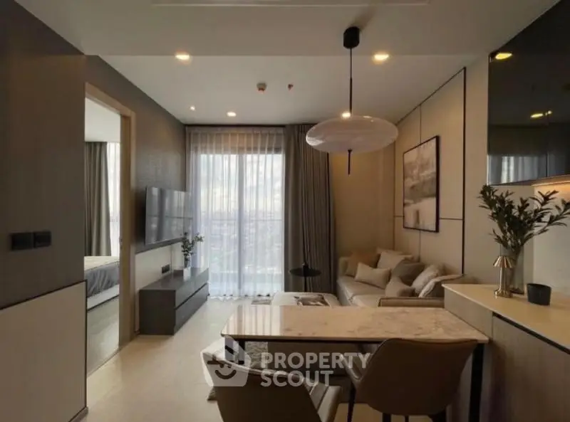Modern living room with elegant decor and natural light, featuring a cozy seating area and stylish dining space.