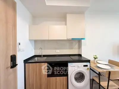 Modern compact kitchen with washing machine and dining area in stylish apartment