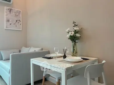Cozy living room with dining area, featuring elegant decor and soft lighting.