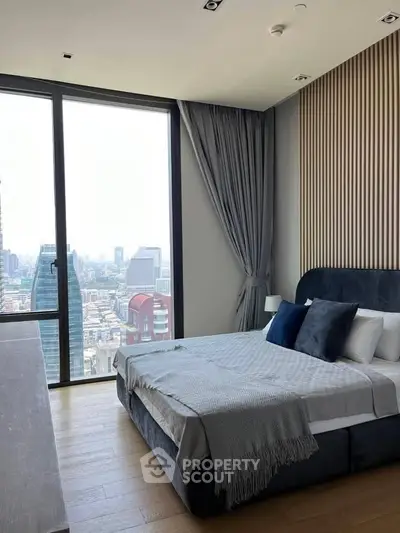 Luxurious bedroom with stunning city view and modern decor in high-rise apartment.