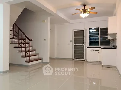 Spacious open-plan living area with modern kitchen and staircase
