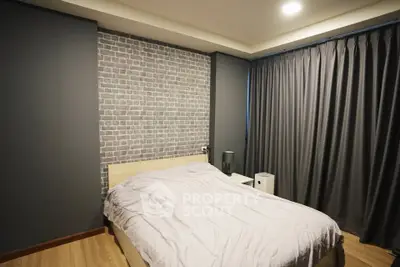 Cozy bedroom with modern decor and soft lighting, featuring a stylish brick accent wall and elegant curtains.