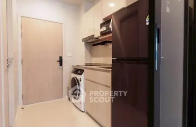 Modern kitchen with sleek appliances and washing machine in compact layout