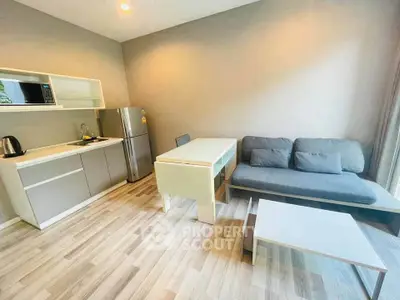 Modern open-layout kitchen and living room with sleek furniture and appliances.