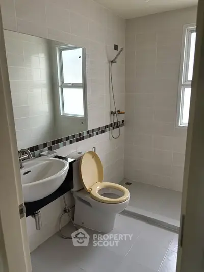 Modern bathroom with sleek fixtures and large mirror in a bright setting.