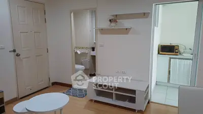 Cozy apartment interior with open layout, featuring a compact kitchen and bathroom, ideal for urban living.