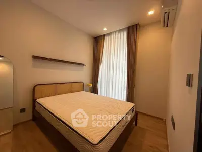 Spacious bedroom with modern design and natural light, featuring a comfortable bed and elegant decor.